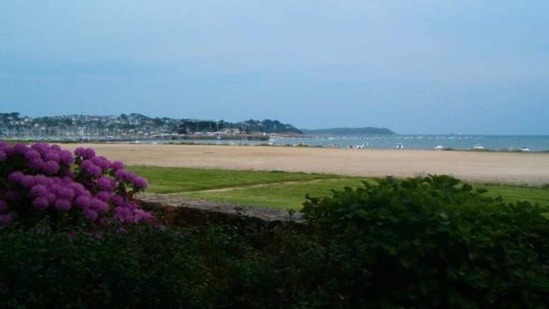 A beach with a view of a coastal town in the background.