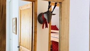 Una puerta de madera con un corte en forma de corazón y un ciervo montado en la pared, con astas.