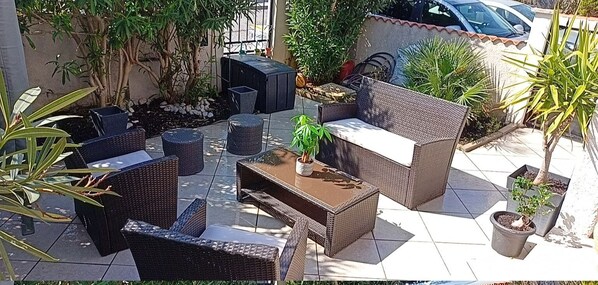 An outdoor patio area with wicker furniture, a central table with a plant, and potted plants around. - Villa F6 10 minutes from the beach, frontignan plage (Frontignan)