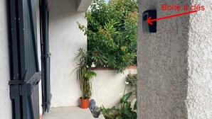 Un patio cubierto con suelo de baldosas, una planta en maceta y una pequeña estatua.