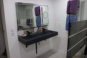 A modern bathroom with a black sink, a mirror, and a towel rack. - Villa F6 10 minutes from the beach, frontignan plage (Frontignan)