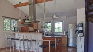 A modern kitchen with a central island, bar stools, a refrigerator, and a phone. - VILLA "La Crau" Exceptional Provencal oasis with private saltwater pool  (Arles)