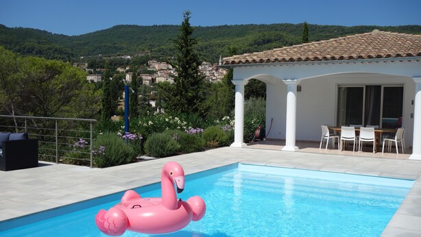 A swimming pool with a pink flamingo float, a white gazebo, and a view of a hillside town. - Villa with pool between the Côte d'Azur and the Gorges du Verdon (8 people) (Callas)