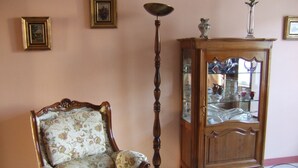 A room with a floral-patterned armchair, a tall floor lamp, and a wooden cabinet with glass doors. - House with garden not overlooked in Bergerac quiet (Bergerac)