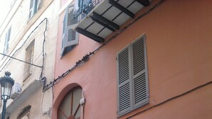 Un edifici amb façana rosa, una porta de fusta i una finestra petita.