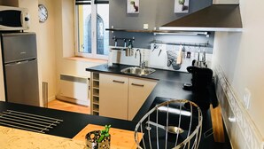 A compact kitchen with a microwave, sink, and a window. - Quiet, air-conditioned apartment for 4 in city center (Cassis)