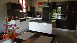 Een moderne keuken met zwart-wit keukenkastjes, een centraal eiland en een raam dat voor natuurlijk licht zorgt.