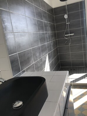 Een douche, een haardroger, handdoeken, toiletpapier