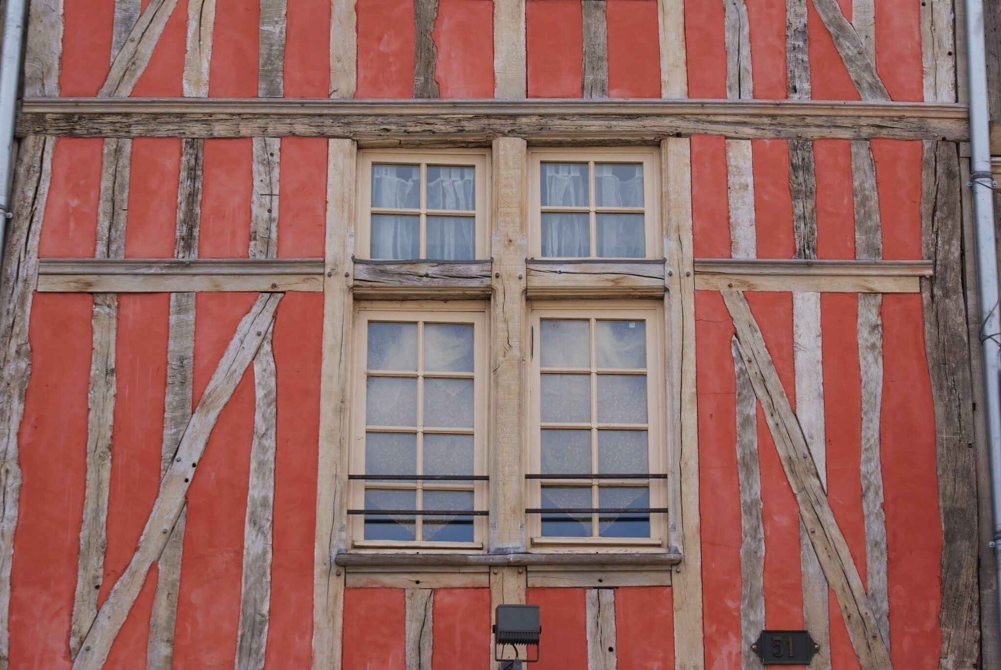 A building facade with a timber frame and a red and white color scheme.