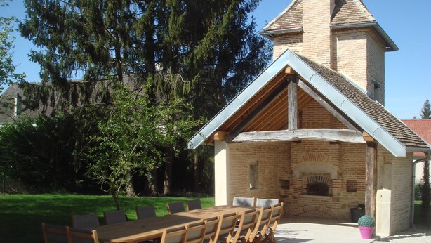 A rustic stone building with a wooden table and chairs set outside. - house high capacity with private pool (Meursanges)