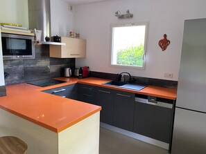 A modern kitchen with a built-in oven, a sink, and a dishwasher.