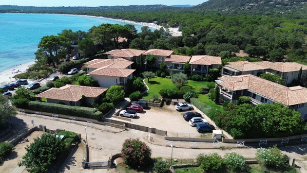 A coastal residential area with terraced houses, a beach, and a parking lot.
