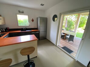 A modern kitchen with a built-in oven, a refrigerator, and a window providing natural light.