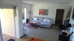 A modern living room with a sofa, coffee table, and a colorful rug.