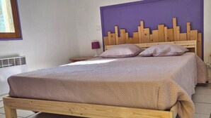 Un lit avec un cadre en bois et une couvre-lit beige à motifs.