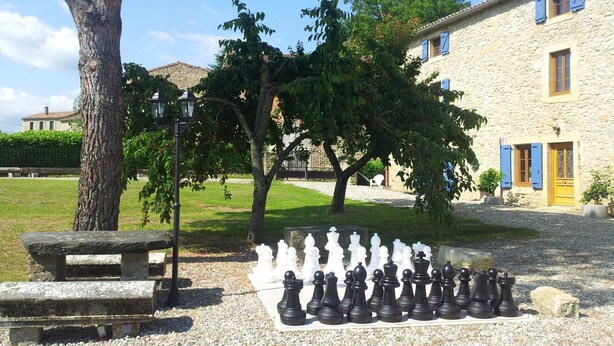 A chessboard set outdoors with a stone bench nearby. - Four independent cottages in an old farmhouse with swimming pool - "Loire" (Limbrassac)