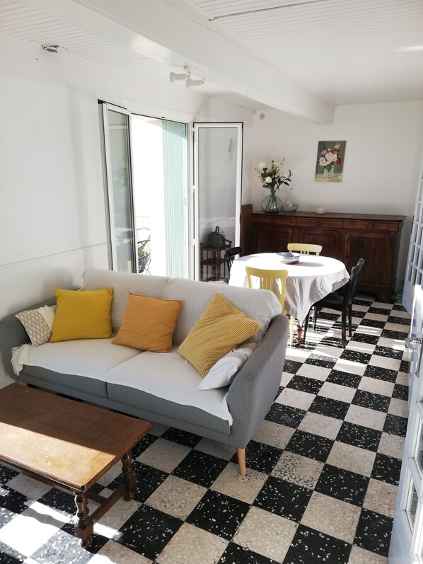 A living room with a sofa, a table, and a checkered floor.