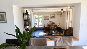 Un salon moderne avec une table basse en verre, une plante en pot et un panier tressé.