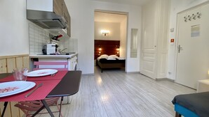 Une cuisine compacte avec un coin repas, un lit et une salle de bain.