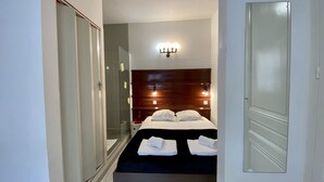 Une chambre à coucher avec un lit, une armoire et un miroir.