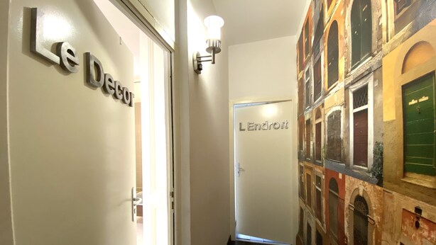 Un couloir avec une pancarte indiquant « Le Début » et une autre indiquant « L’Endroit ».