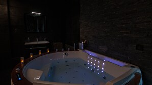 A modern bathroom with a freestanding bathtub, a vanity, and a mirror. - Suite on 3 levels. Spa, jacuzzi, sauna and hammam. (Metz)