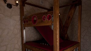 A wooden four-poster bed with a red canopy, metal railings, and wall-mounted light fixtures. - Suite on 3 levels. Spa, jacuzzi, sauna and hammam. (Metz)
