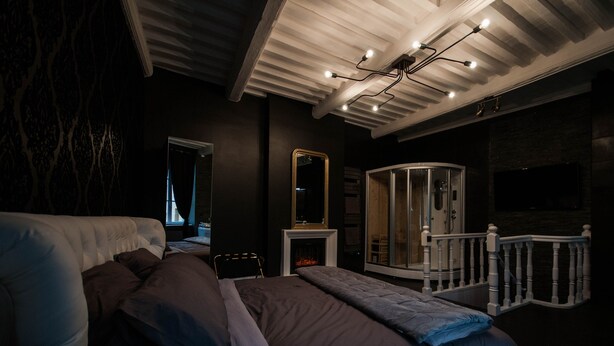 A bedroom with a large bed, a glass-enclosed walk-in closet, a fireplace, and a ceiling light fixture. - Suite on 3 levels. Spa, jacuzzi, sauna and hammam. (Metz)