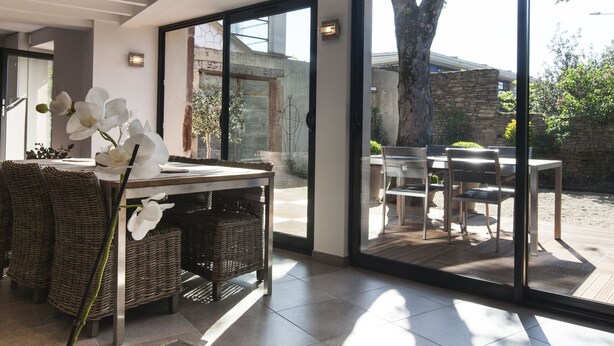 A modern interior with a dining area, wicker furniture, and a view of the outdoor patio. - House-loft 200m from downtown with garden and free parking (Beaune)
