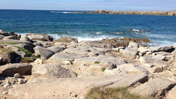 Una costa rocosa con grandes rocas y una vista despejada del mar.