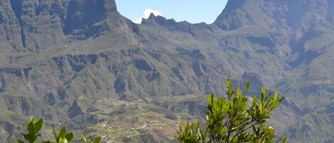 A mountainous landscape with a valley in the foreground and a village below.