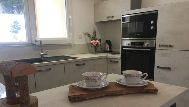 Una cocina moderna con horno empotrado, un lavamanos y una ventana.