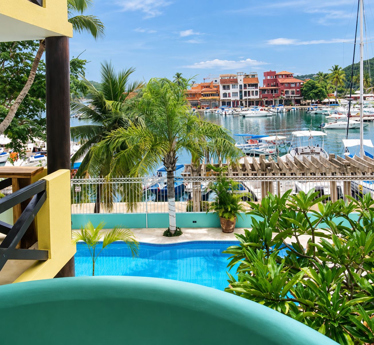A pool area with a view of a marina and buildings in the background.