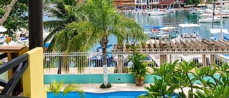 A pool area with a view of a marina and buildings in the background.