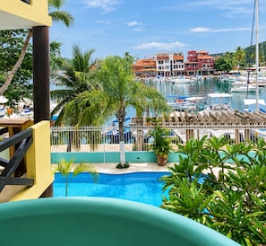 A pool area with a view of a marina and buildings in the background.