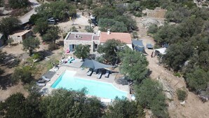 An aerial view of a property with a swimming pool, stone house, and surrounding trees. - Villa in Lumio, large swimming pool, wooded park   (Lumio)