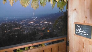 A wooden balcony with a sign reading "Studio" overlooking a cityscape at night. - Studio with a View of Mont Blanc in Sallanches (Sallanches)
