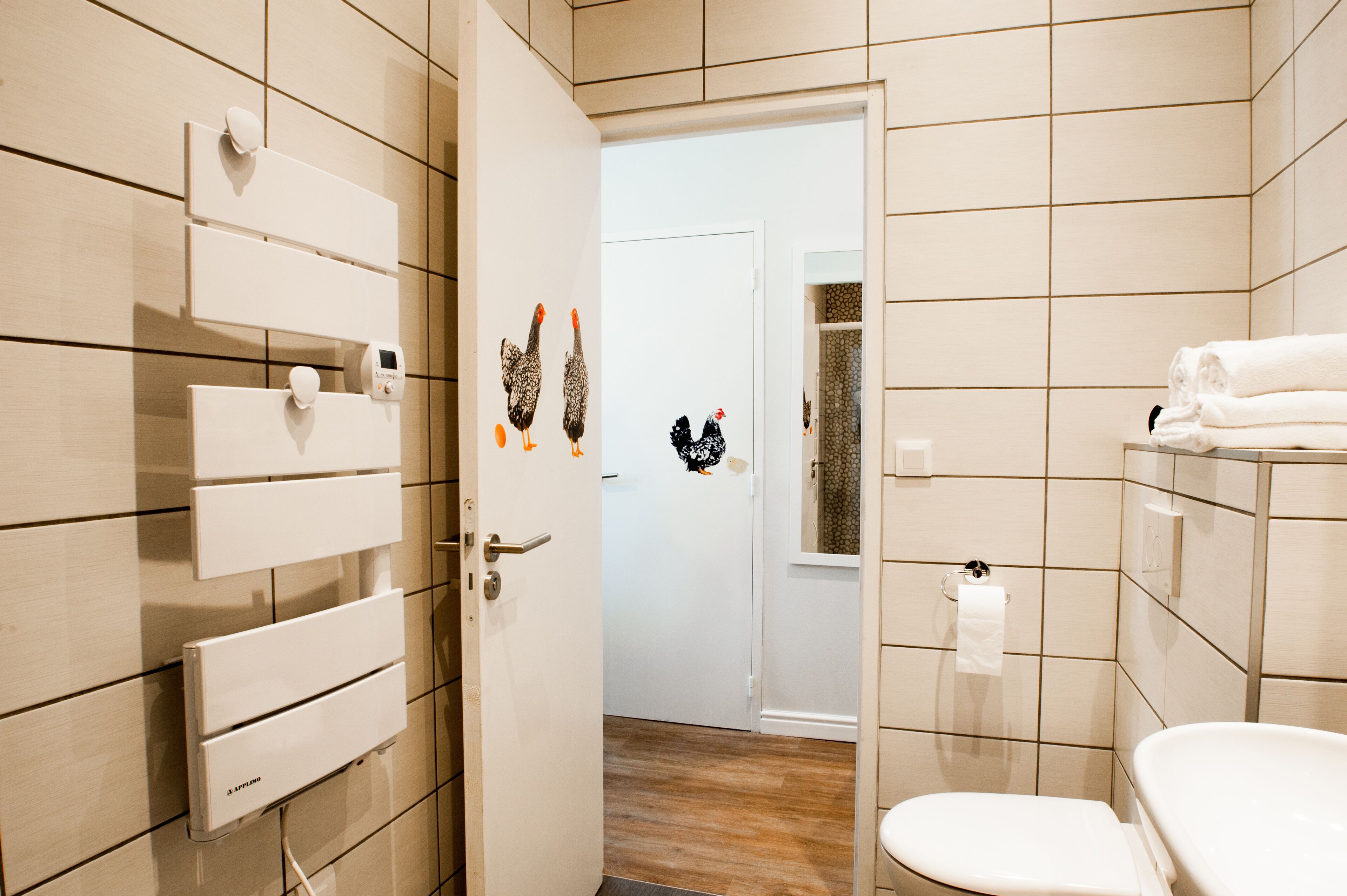 Un baño con inodoro, lavamanos y perchero para toallas.