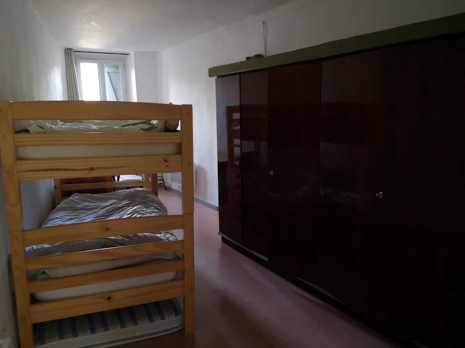 Ein Zimmer mit einem Etagenbett, einem Kleiderschrank und einer Tür.