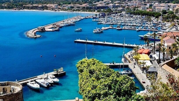 A coastal marina with numerous boats docked, a pier extending into the water, and a backdrop of residential buildings. - SUPERB RENT ANY COMFORT - POOL - BOULODROME - PRIVATE PARKING IN PEACE (Calenzana)