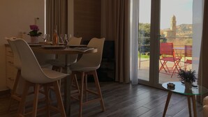 Un comedor con una mesa dispuesta para dos, un televisor y vistas al exterior.