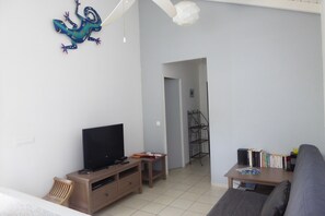 A living room with a television, a bookshelf, and a sofa. - charming little 2 bedroom villa with private pool in residential area (SAINT FRANCOIS)