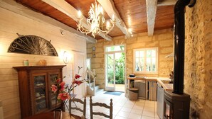 A rustic interior with a wooden dining table, a fireplace, and a chandelier.