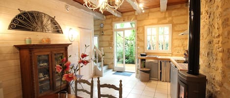 Un interior rústico con comedor, chimenea y vistas al exterior.