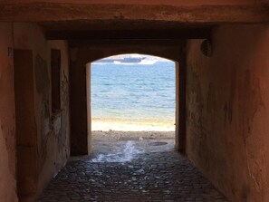 A narrow, cobblestone pathway leading to a beach through an arched doorway. - Promo:Charming apartment, old St-Tropez, near church, la Ponche, 2 beds (Saint-Tropez)