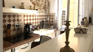 Eine Küche mit Steinwand, einer Kaffeemaschine und einem Spülbecken.