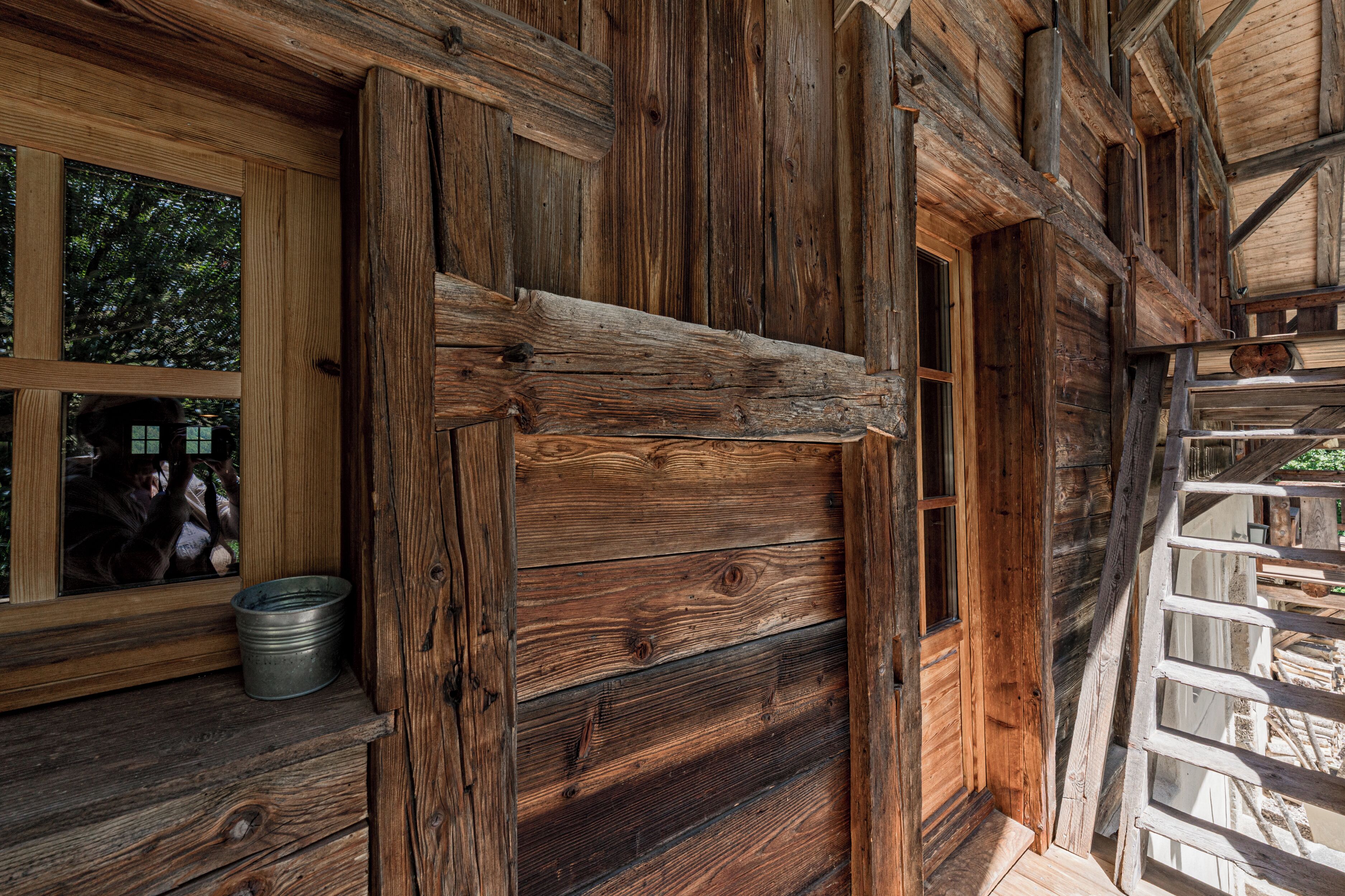 A rustic wooden cabin with a large window and a door.