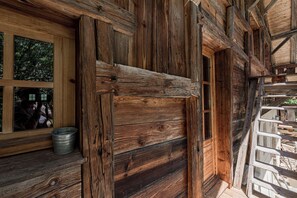 A rustic wooden cabin with a large window and a door.