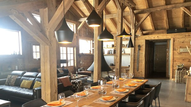 A rustic wooden interior with a long dining table set for a meal, surrounded by modern chairs. - Exceptional "Frachette" Chalet (Praz-Sur-Arly)