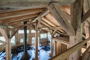 A wooden interior with a high ceiling and exposed beams, a sofa set, and a fireplace. - Exceptional "Frachette" Chalet (Praz-Sur-Arly)